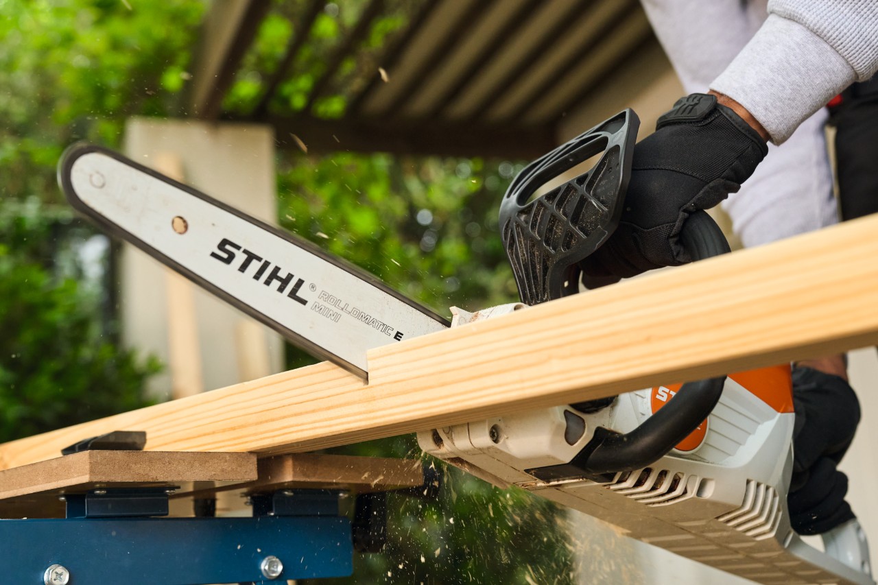 Мъж реже по размери странична подпора за футболна врата със STIHL MSA 70