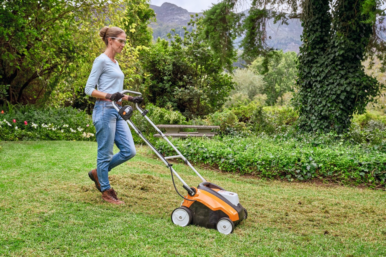 Жена вертикутира тревата с акумулаторен аератор STIHL RLA 240