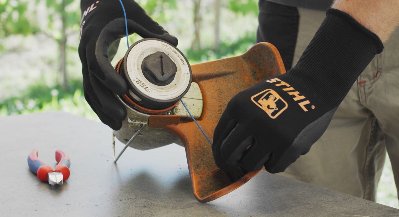 Мъж навива корда на акумулаторна моторна коса STIHL FSA 57