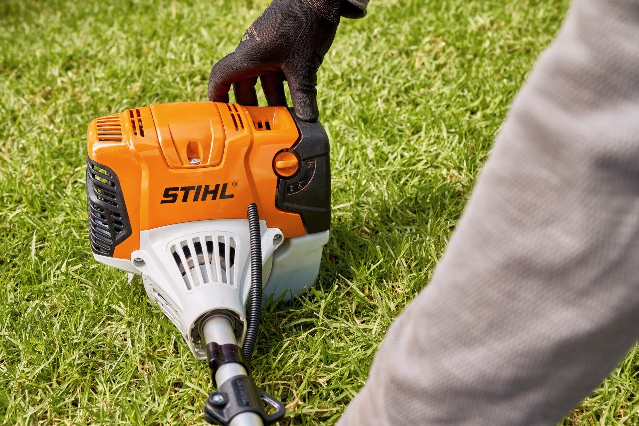Мъж притиска здраво бензиновата моторна косачка STIHL FS 91 към земята