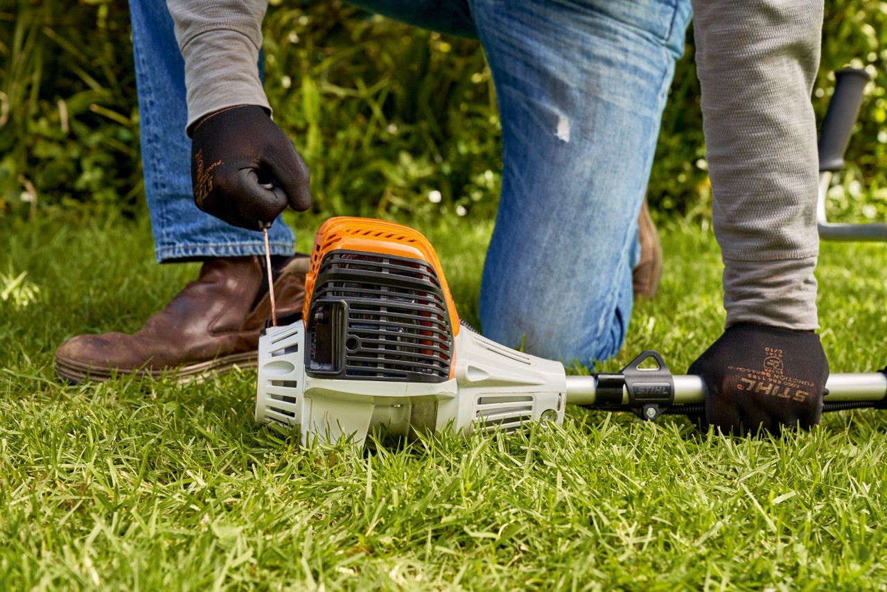 Мъж дърпа стартиращото въже на бензиновата моторна косачка STIHL FS 91 