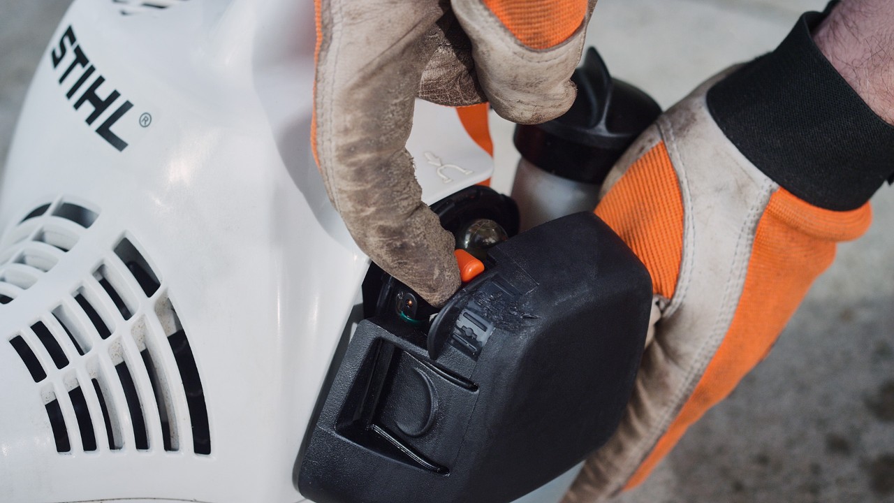 На бензиновата моторна косачка STIHL FS 38 се задейства лостът на стартовата клапа