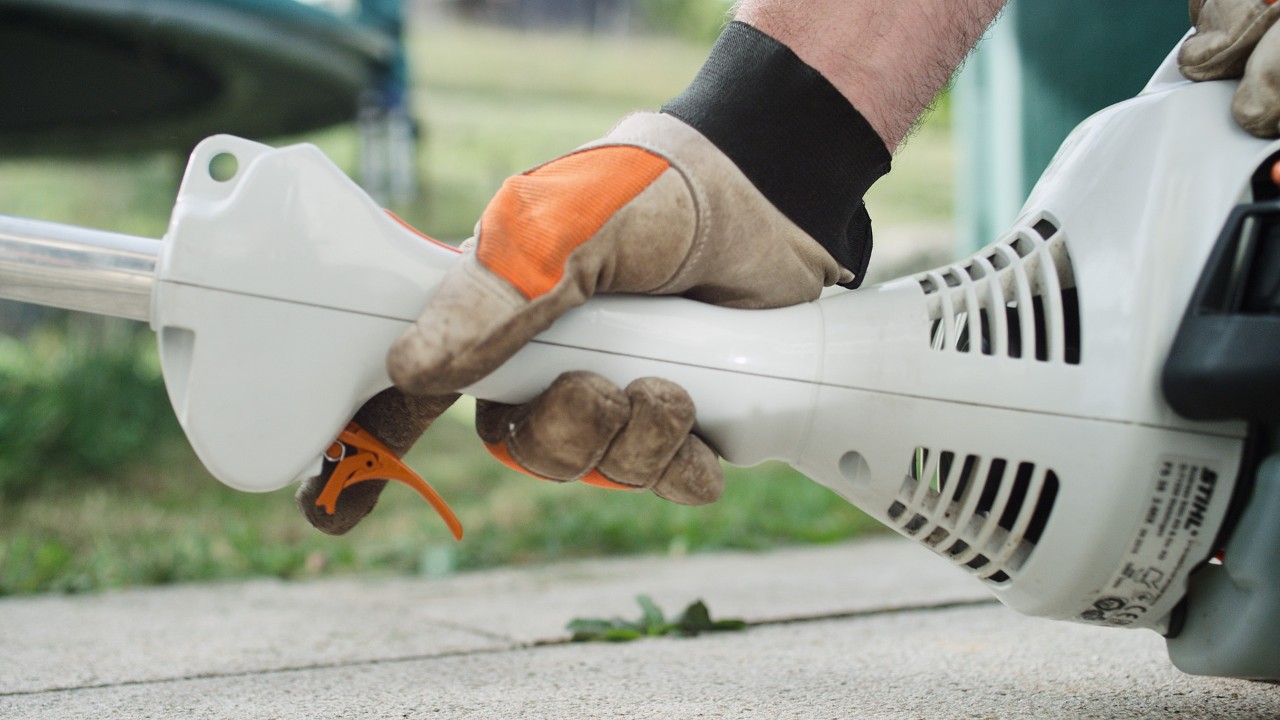 На бензиновата моторна косачка STIHL FS 38 се натиска лостът за газта