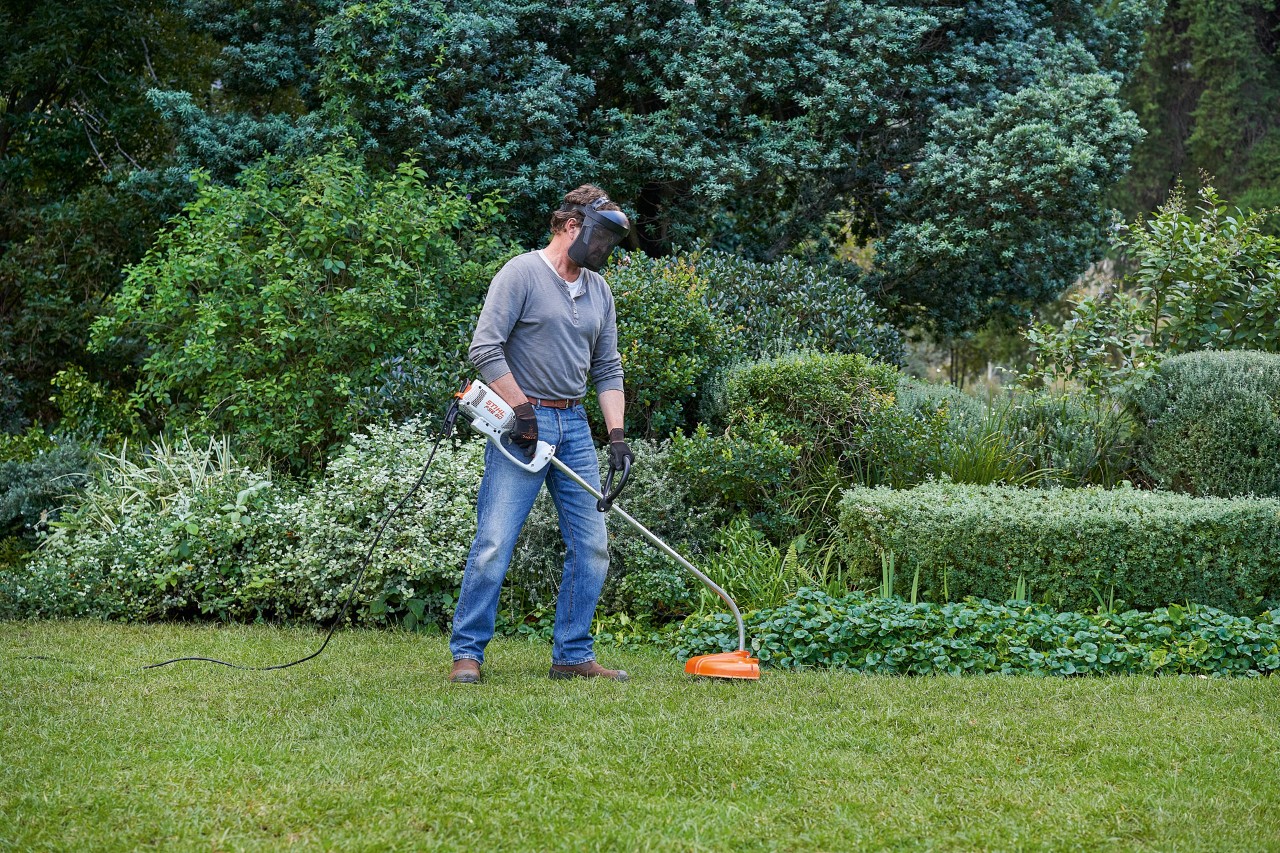 Мъж с електрическа моторна косачка STIHL FSE 60 заема сигурна позиция
