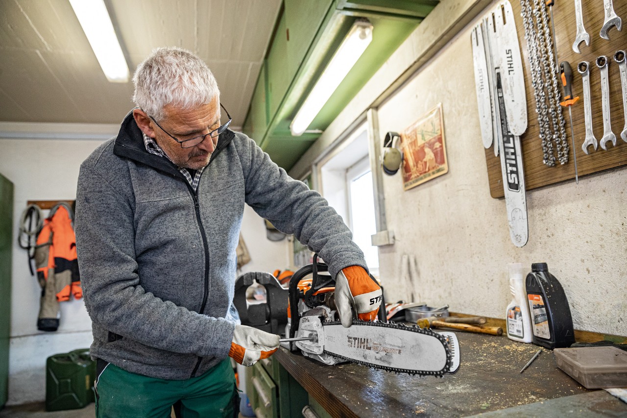Мъж обтяга веригата на верижен трион STIHL