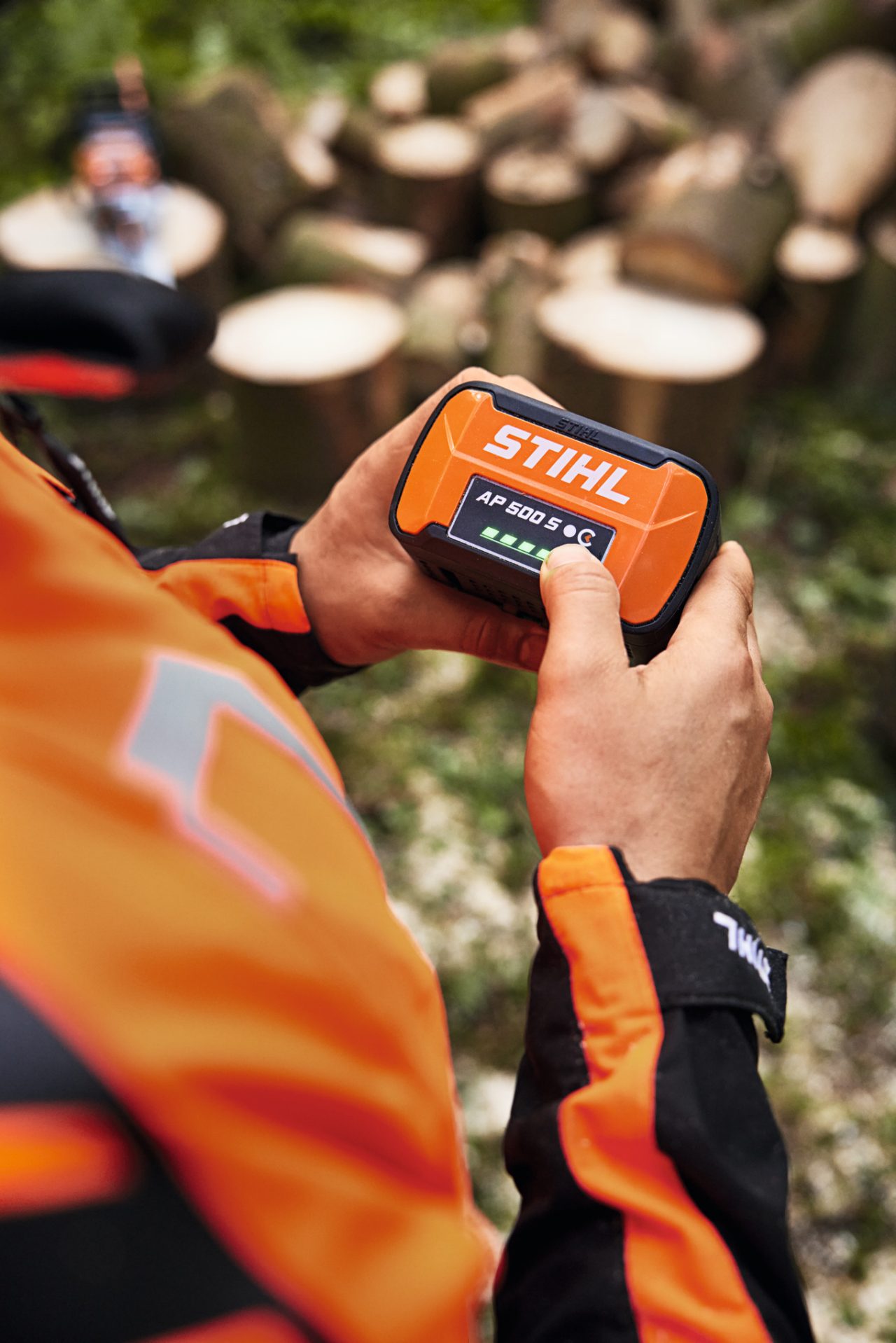 Снимка в близък план на човек, който държи литиево-йонната батерия STIHL AP 500 S в ръцете си
