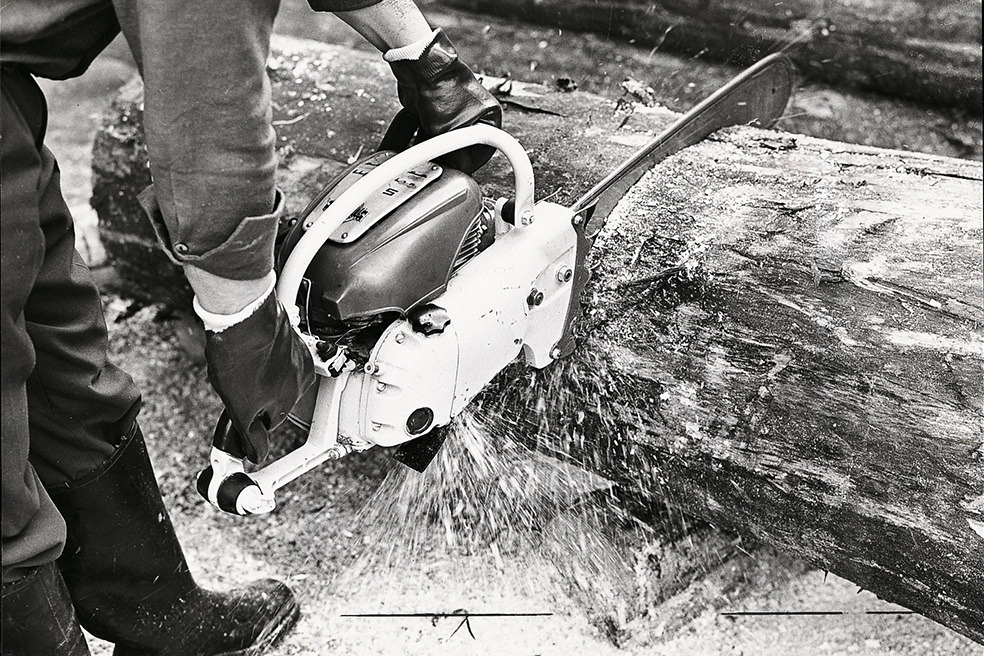 Стара черно-бяла снимка как някой срязва дърво с моторния трион STIHL Contra 