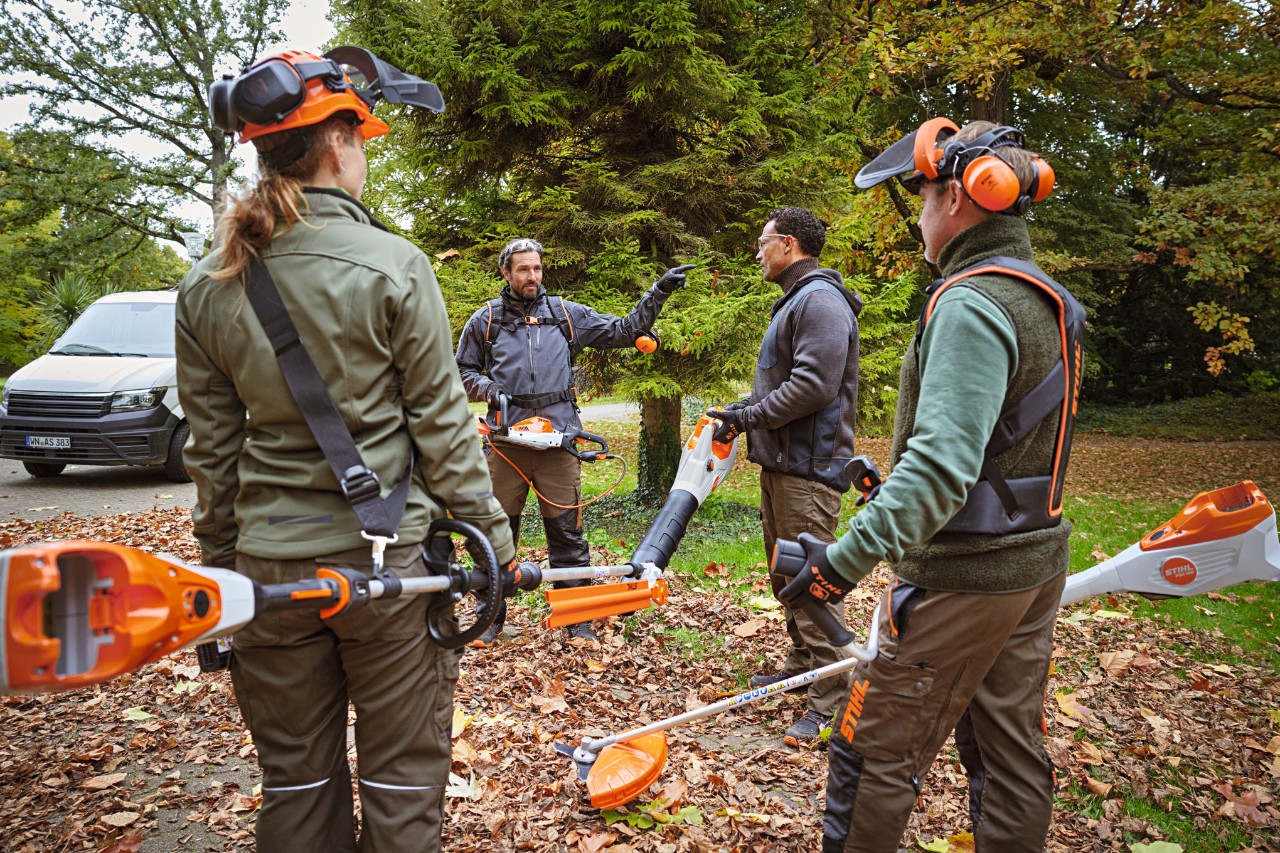 Работници от фирма по озеленяване с акумулаторни уреди STIHL се подготвят да започнат работа