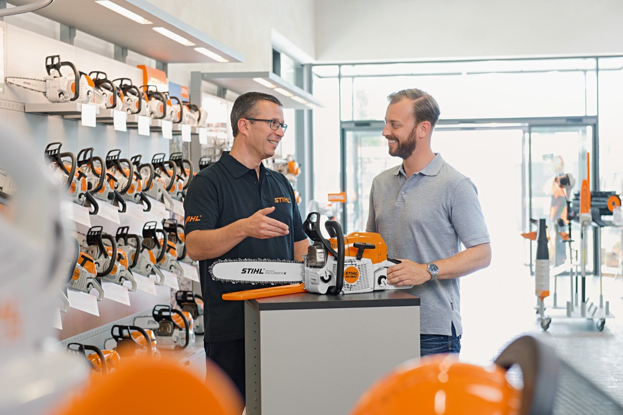 Специализиран търговец на STIHL консултира мъж при покупката на верижен трион STIHL